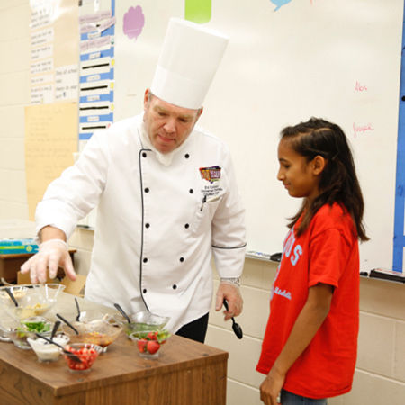 Chef at Universal Orlando Resort provides instruction to a student