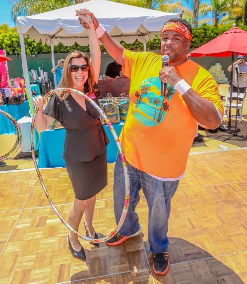 USH Team Member holding up the hand of a guest holding a hula hoop