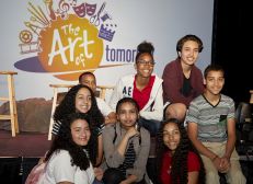 Group of students on a stage with 'The Art of Tomorrow' in the backdrop.