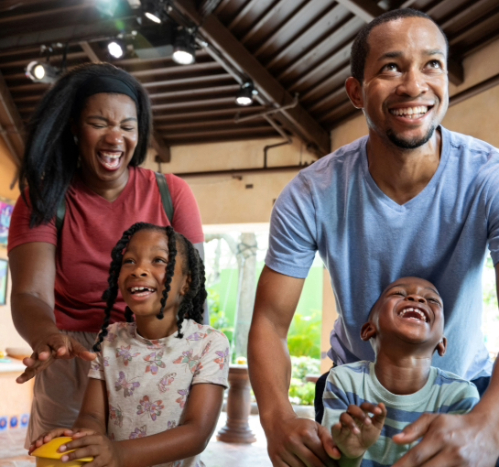 Family of four with two kids enjoying an interactive area of a theme park.
